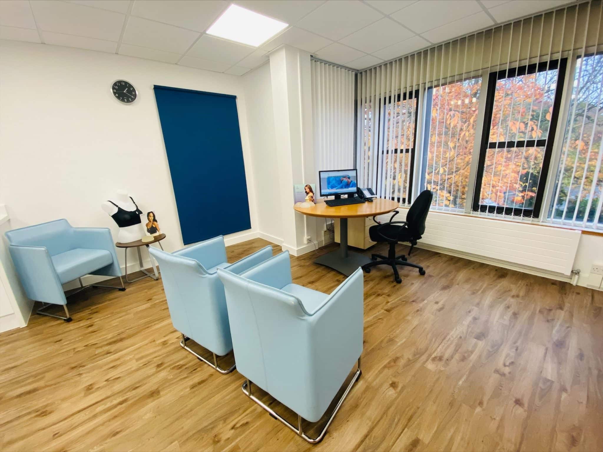Photo of the inside of The Harley Medical Group, Brentwood clinic consultation room, with two blue chairs, and a table